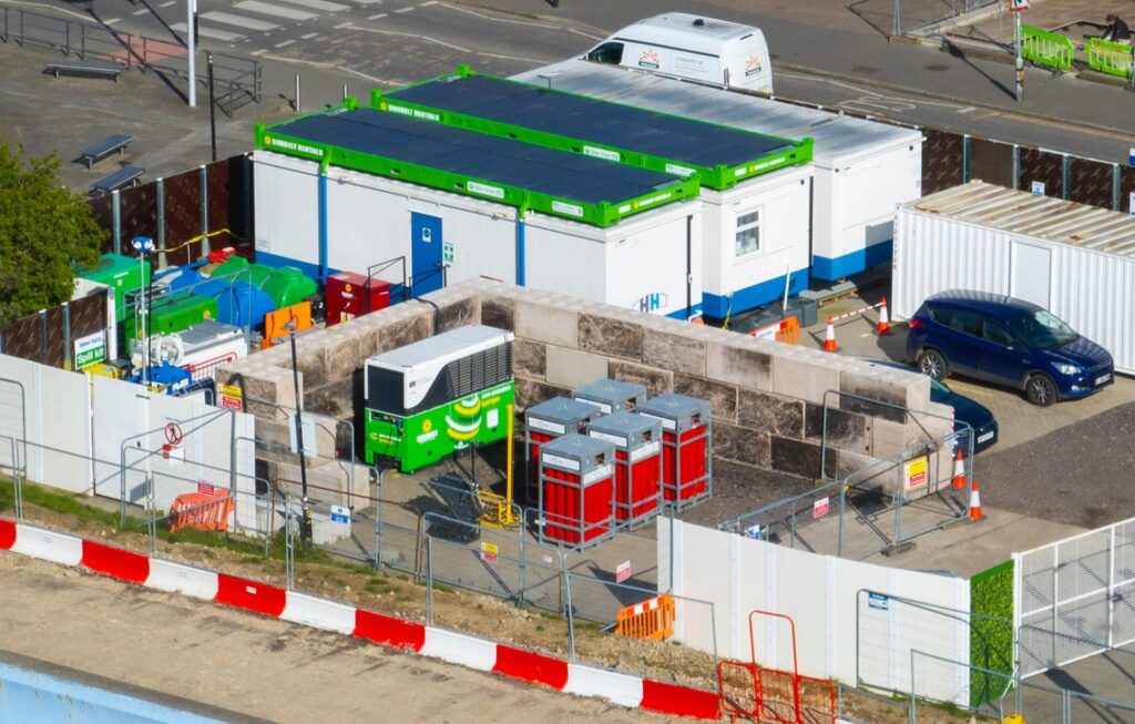 Aerial view of SBR Hydrologiq off-grid power installation at Canvey Island with solar panels, battery storage, and modular...