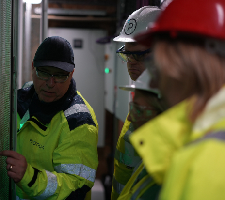 Technical service professionals in safety gear collaborating on industrial equipment inspection and maintenance.